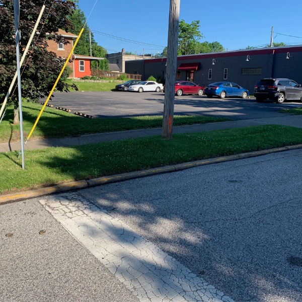 A paved street with a faded yellow curb